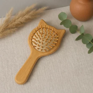 Brosse en bois ayurvédique à coussin d’air sur une table en lin avec plantes naturelles
